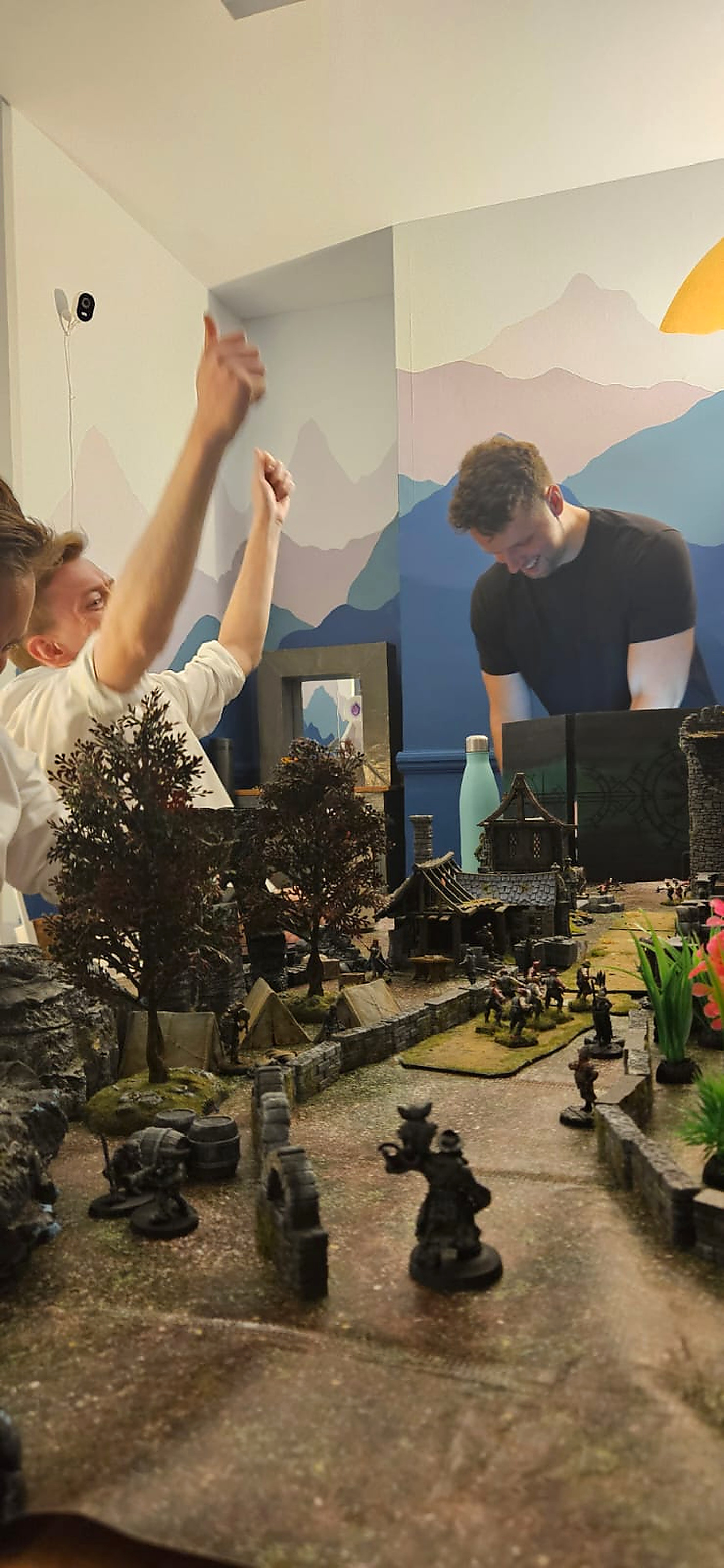 A player celebrating with both arms raised over the battle map