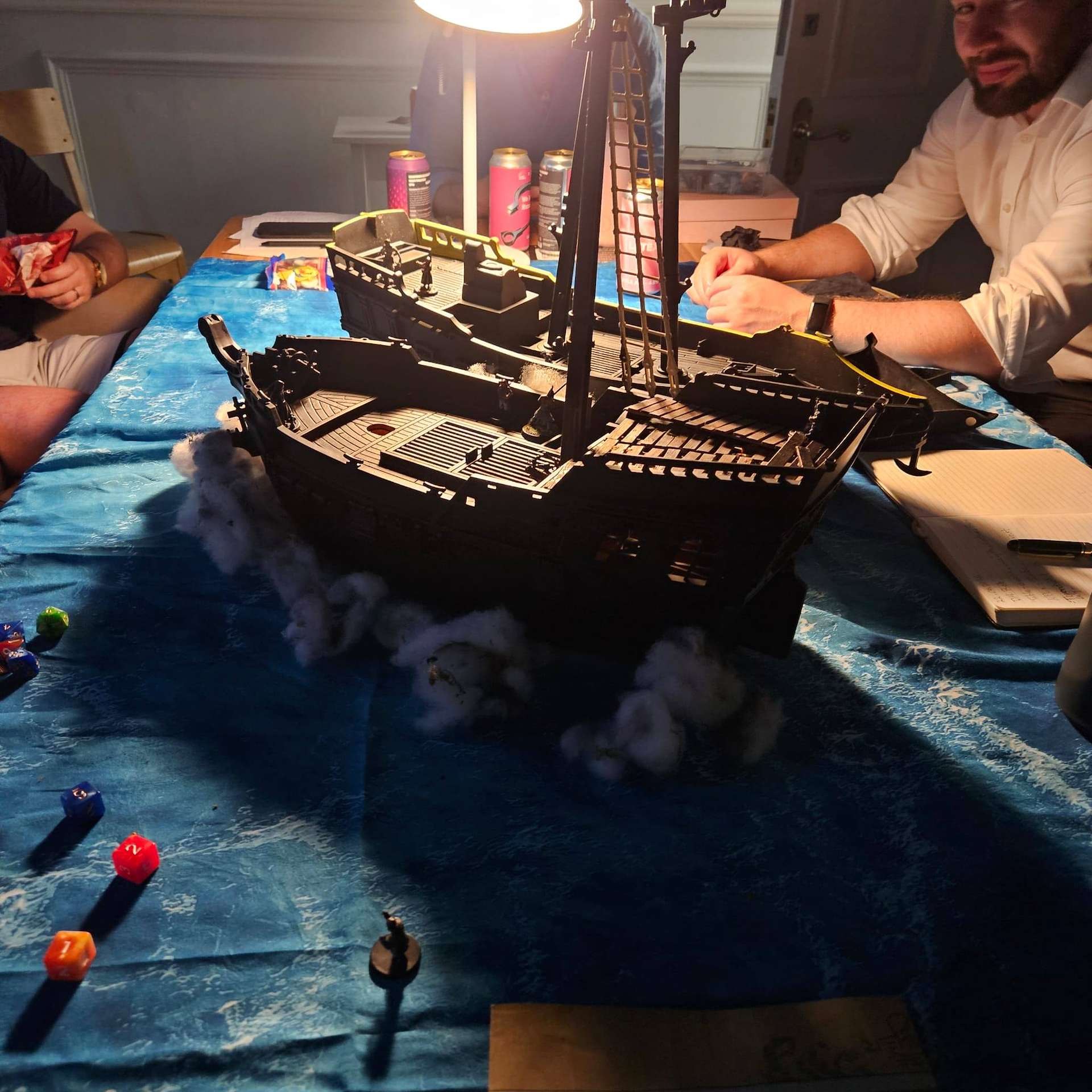 A model pirate ship sailing a blue cloth sea
