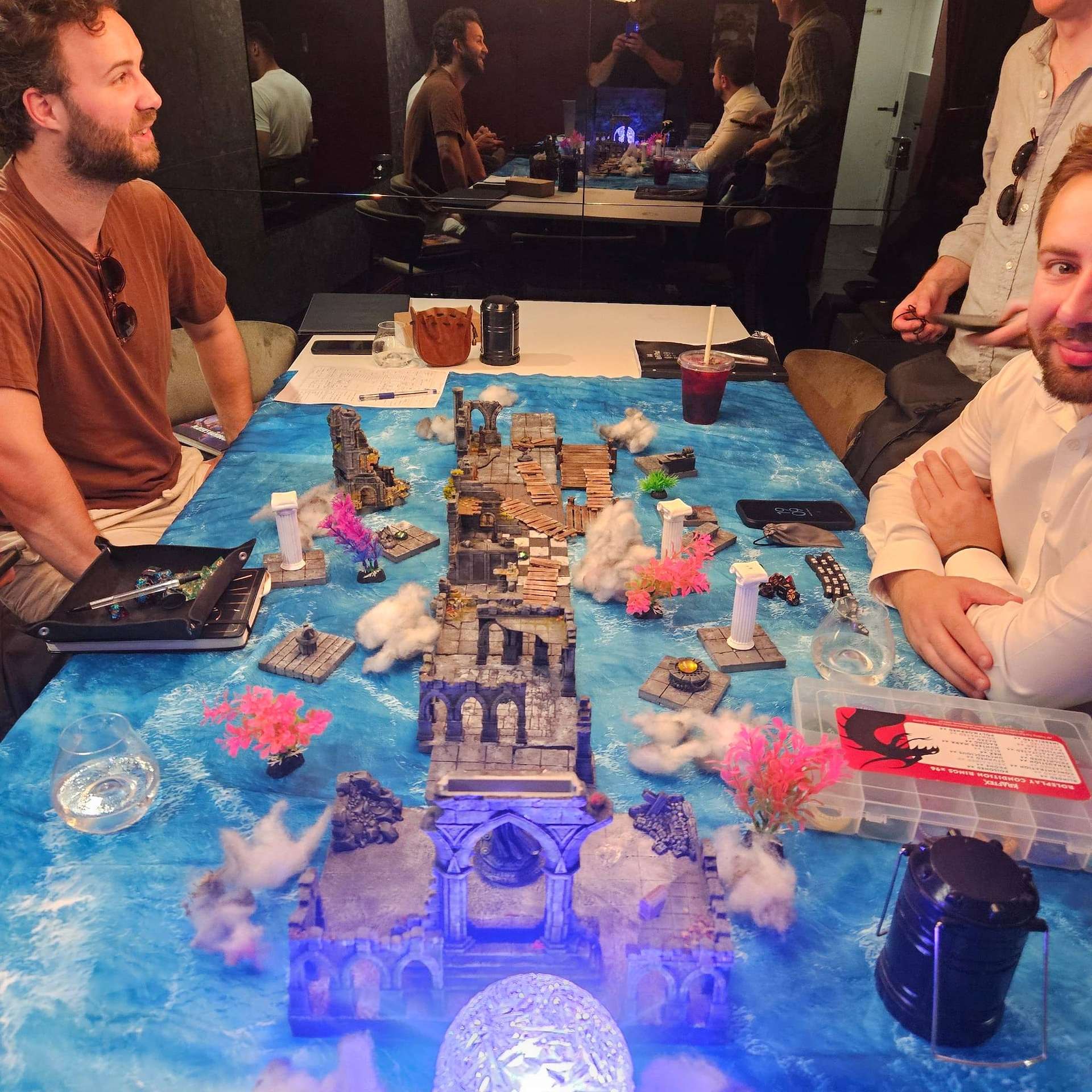 Players leaning in around the glowing battle map