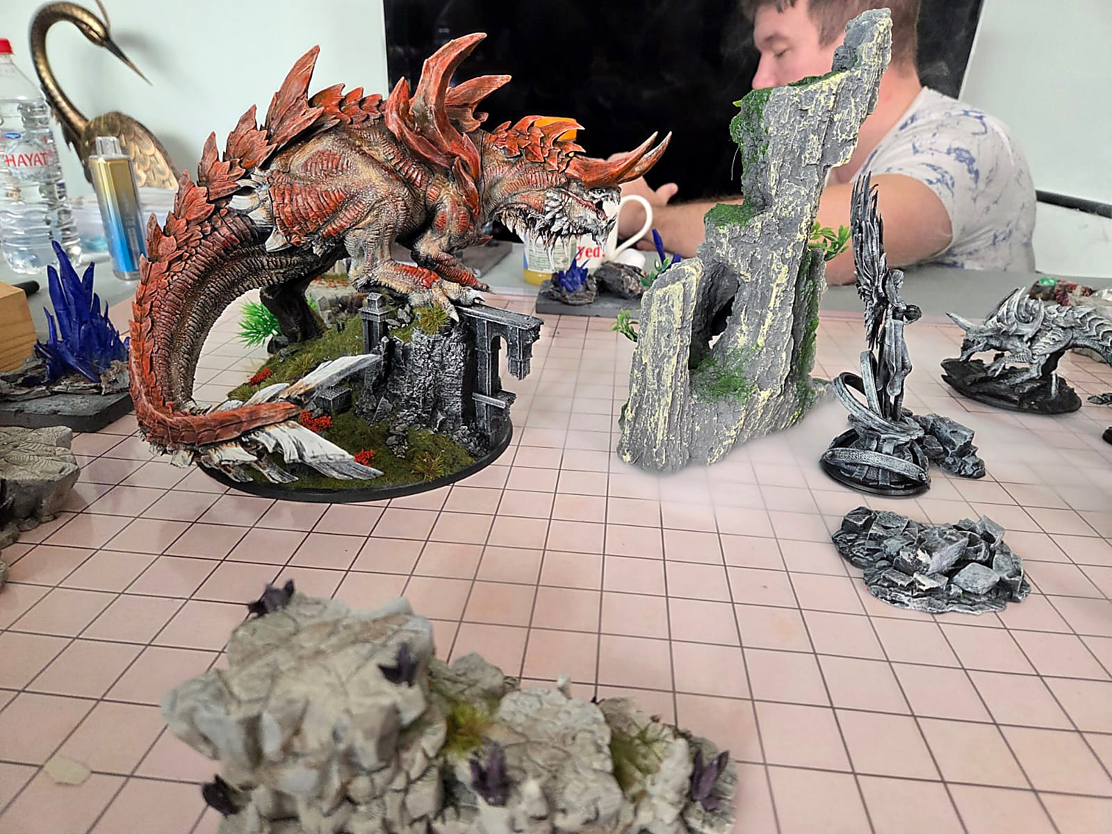 A huge red and orange spined dragon rearing over broken stone terrain