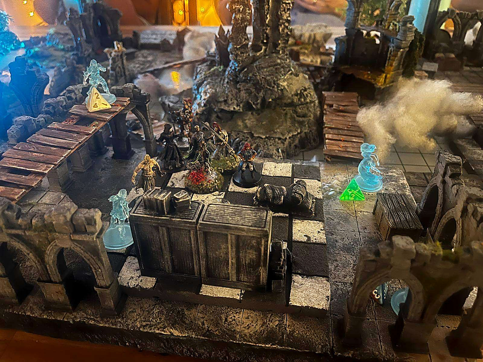 A castle siege laid out across the table with cotton smoke and miniatures