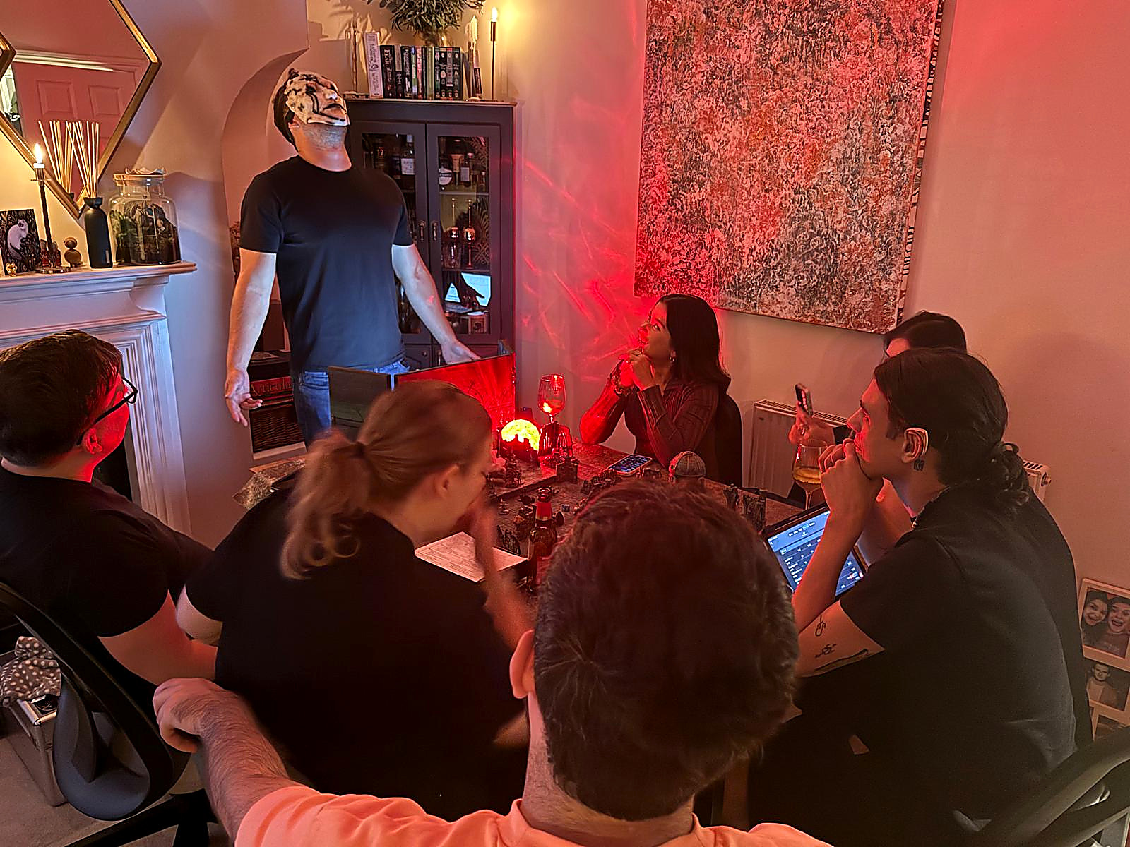 The game master in a monster mask performing for the table by candlelight